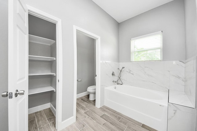 2448 Areba St, Houston, TX 77091 - full bathroom featuring a garden tub, toilet, wood finish floors, and baseboards