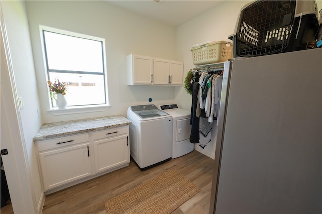 11552 Renaissance Dr, Montgomery, TX 77356 - washroom with cabinet space, light wood-type flooring, and independent washer and dryer