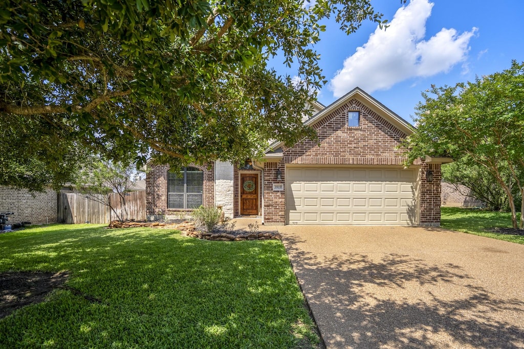 3919 Incourt Ln, College Station, TX 77845 - obstructed view of property featuring a garage, concrete driveway, and brick siding