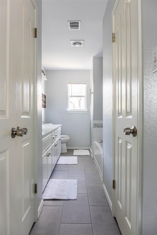 300 Coventry Rd, Spicewood, TX 78669 - full bathroom featuring tile patterned flooring, vanity, toilet, baseboards, and combined bath / shower with glass door