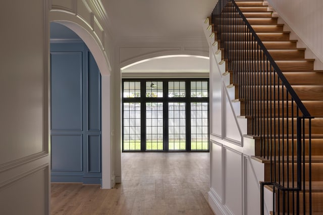 2218 Bartlett St, Houston, TX 77098 - hallway with a decorative wall, arched walkways, wood finished floors, crown molding, and stairs