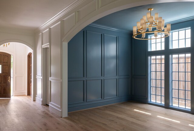 2218 Bartlett St, Houston, TX 77098 - interior space featuring a decorative wall, arched walkways, ornamental molding, a chandelier, and wood finished floors