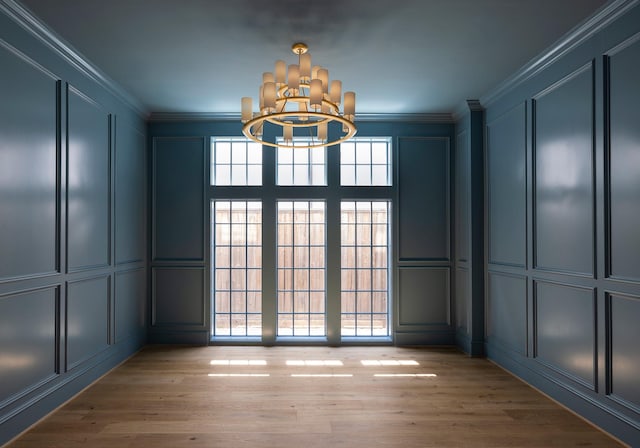 2218 Bartlett St, Houston, TX 77098 - unfurnished room featuring a decorative wall, a chandelier, ornamental molding, and light wood-type flooring