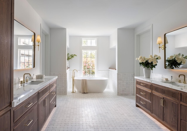 2218 Bartlett St, Houston, TX 77098 - full bath with a wainscoted wall, tile walls, two vanities, and a soaking tub