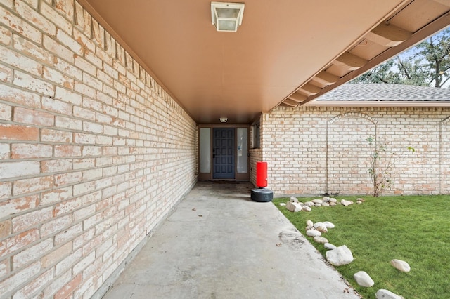 8818 Arbor Wood Dr, Houston, TX 77040 - view of exterior entry with brick siding, a shingled roof, and a yard