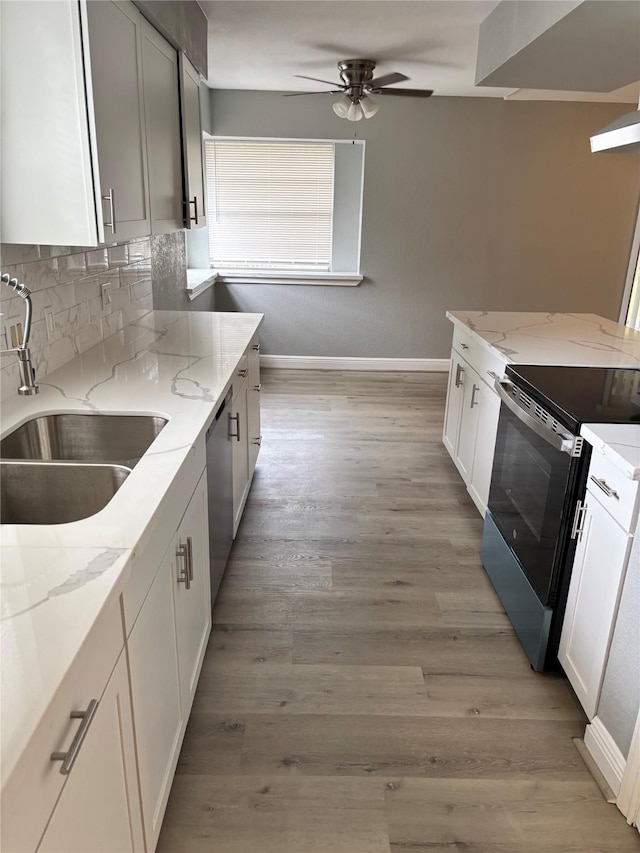 8818 Arbor Wood Dr, Houston, TX 77040 - kitchen featuring wall chimney range hood, a sink, baseboards, appliances with stainless steel finishes, and ceiling fan