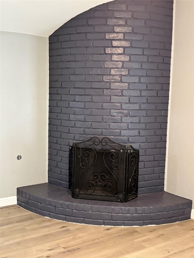 8818 Arbor Wood Dr, Houston, TX 77040 - detailed view of a brick fireplace, baseboards, and wood finished floors