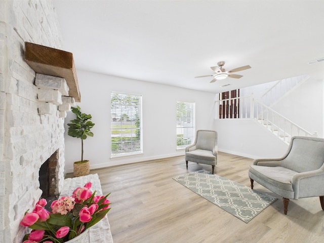 19503 Atascocita Shores Dr, Humble, TX 77346 - living area featuring wood finished floors, a ceiling fan, stairs, and a fireplace