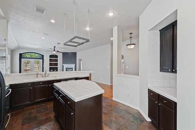 7931 Clarion Way, Houston, TX 77040 - kitchen with a sink, a ceiling fan, stone tile flooring, tile countertops, and tasteful backsplash