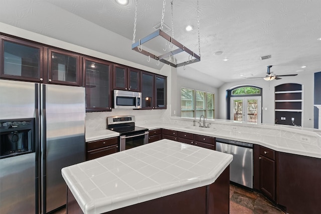 7931 Clarion Way, Houston, TX 77040 - kitchen with appliances with stainless steel finishes, a sink, a center island, a peninsula, and dark brown cabinets