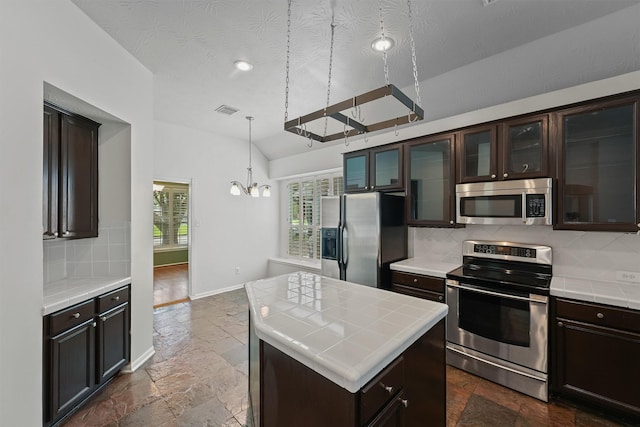 7931 Clarion Way, Houston, TX 77040 - kitchen featuring stainless steel appliances, stone tile floors, a chandelier, tile countertops, and lofted ceiling