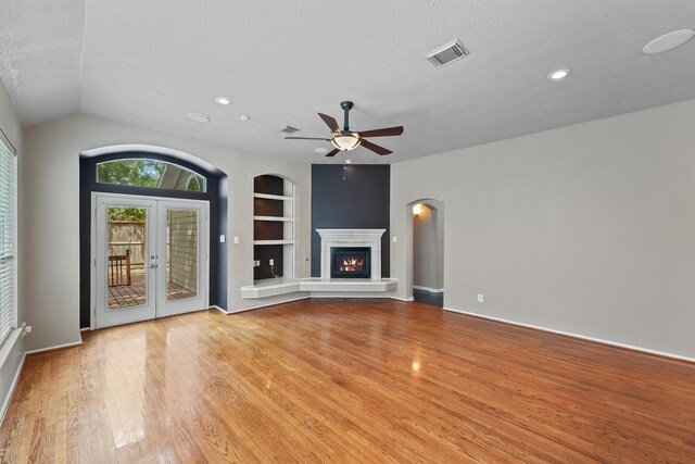 7931 Clarion Way, Houston, TX 77040 - unfurnished living room with built in features, light wood-style flooring, ceiling fan, a textured ceiling, and french doors