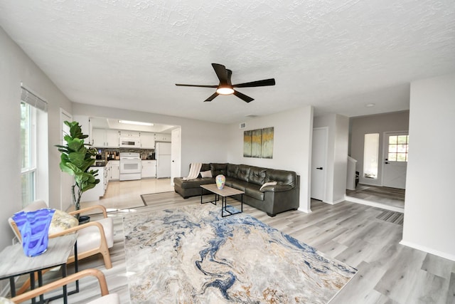 1902 Kings Arms Way, Katy, TX 77493 - living room with ceiling fan, light wood-style flooring, and a textured ceiling