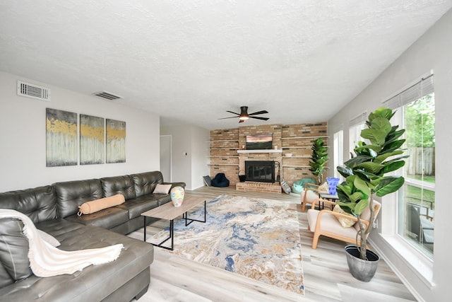 1902 Kings Arms Way, Katy, TX 77493 - living area featuring a ceiling fan, wood finished floors, a textured ceiling, and a brick fireplace