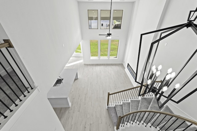 5049 Steady Breeze Dr, Katy, TX 77493 - staircase featuring a towering ceiling, ceiling fan, wood finished floors, and baseboards