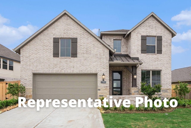 5049 Steady Breeze Dr, Katy, TX 77493 - view of front of home featuring brick siding, driveway, a standing seam roof, and an attached garage