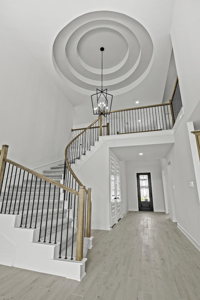 5049 Steady Breeze Dr, Katy, TX 77493 - entryway with a high ceiling, a chandelier, a raised ceiling, stairs, and wood finished floors
