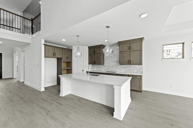 5049 Steady Breeze Dr, Katy, TX 77493 - kitchen featuring a sink, tasteful backsplash, light wood-style flooring, an island with sink, and recessed lighting
