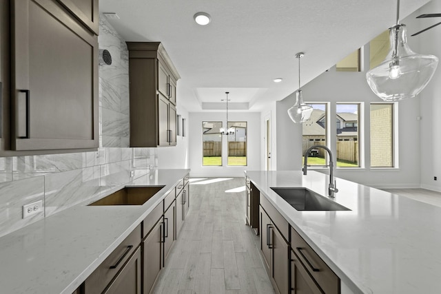 5049 Steady Breeze Dr, Katy, TX 77493 - kitchen featuring a sink, light wood finished floors, healthy amount of natural light, a tray ceiling, and recessed lighting