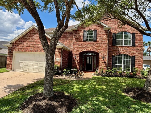 2528 Attwater Way, League City, TX 77573 - traditional home featuring brick siding, a front lawn, an attached garage, and concrete driveway