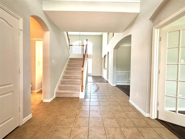 2528 Attwater Way, League City, TX 77573 - foyer entrance with arched walkways, light tile patterned floors, stairs, and baseboards