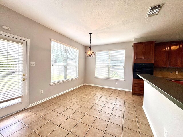 2528 Attwater Way, League City, TX 77573 - kitchen featuring oven, light tile patterned floors, dark countertops, pendant lighting, and baseboards
