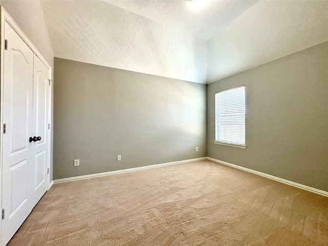 2528 Attwater Way, League City, TX 77573 - unfurnished bedroom featuring vaulted ceiling, carpet floors, baseboards, and a textured ceiling