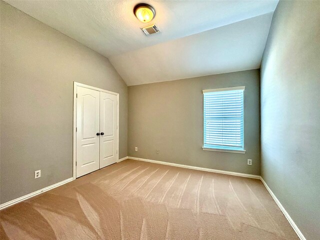 2528 Attwater Way, League City, TX 77573 - unfurnished bedroom featuring carpet floors, baseboards, vaulted ceiling, and a closet
