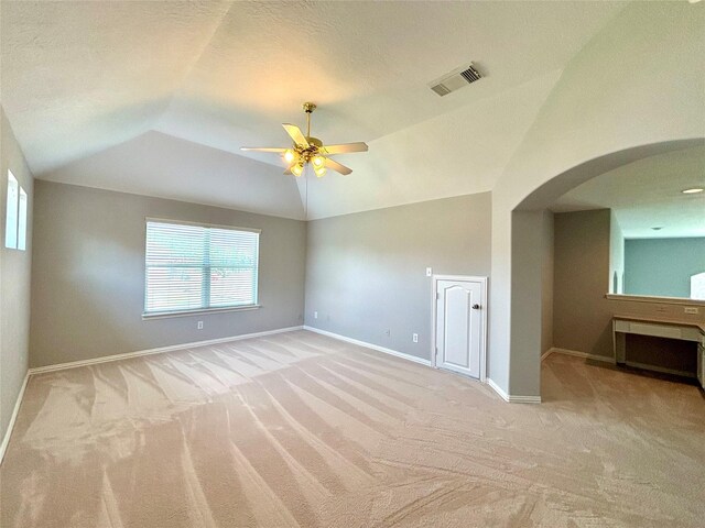 2528 Attwater Way, League City, TX 77573 - empty room featuring light carpet, lofted ceiling, a ceiling fan, arched walkways, and baseboards