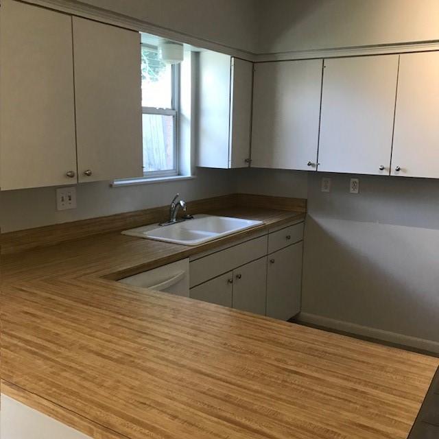 5471 Kuldell Dr, Houston, TX 77096 - kitchen featuring a sink and white cabinets