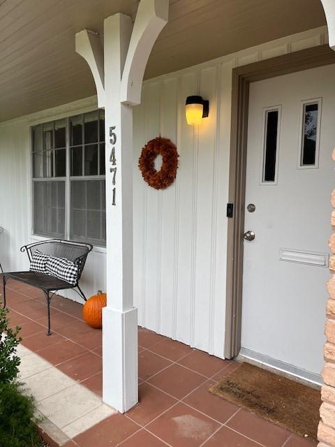 5471 Kuldell Dr, Houston, TX 77096 - view of exterior entry with a porch and board and batten siding