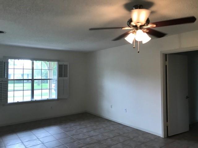 5471 Kuldell Dr, Houston, TX 77096 - tiled empty room with ceiling fan and a textured ceiling