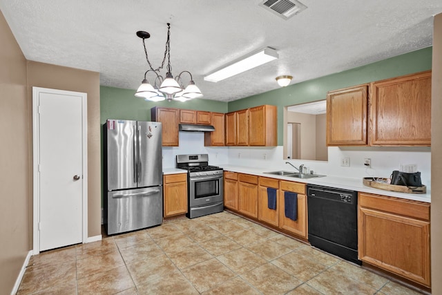 12821 Donegal Way, Houston, TX 77047 - kitchen featuring stainless steel appliances, light countertops, a textured ceiling, under cabinet range hood, and decorative light fixtures