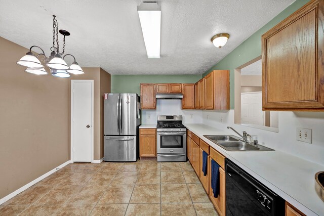 12821 Donegal Way, Houston, TX 77047 - kitchen featuring appliances with stainless steel finishes, under cabinet range hood, light countertops, brown cabinets, and a textured ceiling