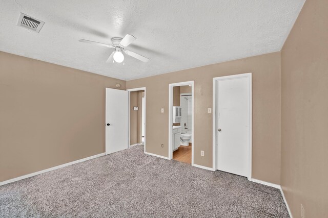 12821 Donegal Way, Houston, TX 77047 - unfurnished bedroom featuring carpet floors, a textured ceiling, ensuite bath, and a ceiling fan