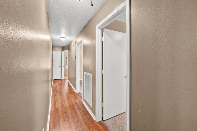 12821 Donegal Way, Houston, TX 77047 - hallway featuring light wood-type flooring and a textured ceiling