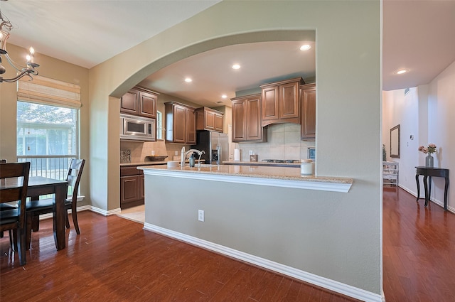 17207 Red Oak Bend Dr, Cypress, TX 77433 - kitchen featuring appliances with stainless steel finishes, arched walkways, dark wood-style flooring, decorative backsplash, and recessed lighting
