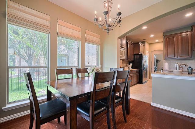 17207 Red Oak Bend Dr, Cypress, TX 77433 - dining area with arched walkways, a chandelier, and light wood-style flooring