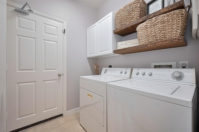 17207 Red Oak Bend Dr, Cypress, TX 77433 - laundry room featuring washer and clothes dryer, cabinet space, light tile patterned flooring, and baseboards
