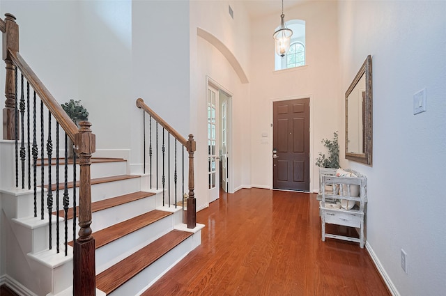 17207 Red Oak Bend Dr, Cypress, TX 77433 - entrance foyer with a towering ceiling, wood finished floors, baseboards, arched walkways, and stairway