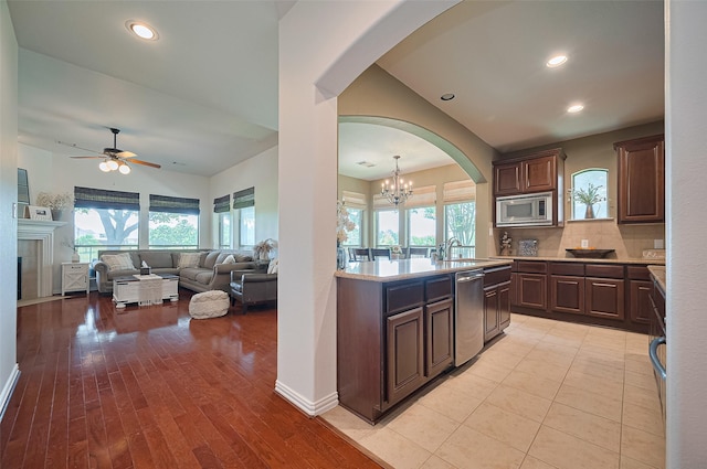17207 Red Oak Bend Dr, Cypress, TX 77433 - kitchen with appliances with stainless steel finishes, arched walkways, light countertops, a ceiling fan, and backsplash
