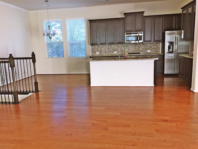 3004 Fairdale Estates Ct, Houston, TX 77057 - kitchen with stainless steel appliances, crown molding, tasteful backsplash, a chandelier, and wood finished floors
