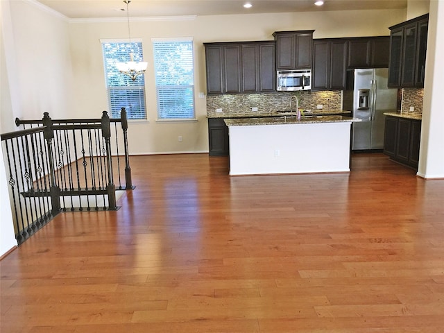 3004 Fairdale Estates Ct, Houston, TX 77057 - kitchen featuring stainless steel appliances, ornamental molding, backsplash, a chandelier, and light wood-style floors