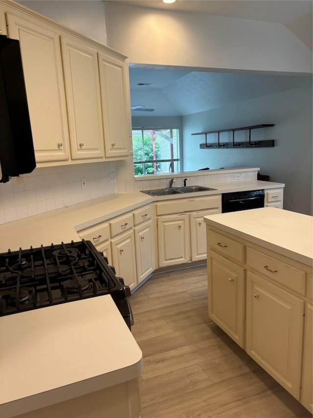 18918 Cypresswood Forest Ct, Spring, TX 77388 - kitchen with black appliances, a sink, light wood-style flooring, light countertops, and decorative backsplash