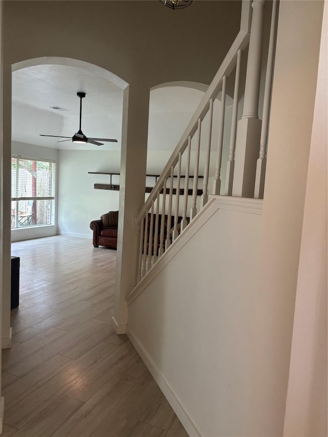 18918 Cypresswood Forest Ct, Spring, TX 77388 - staircase featuring arched walkways, baseboards, a ceiling fan, and wood finished floors