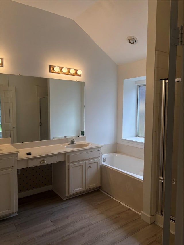 18918 Cypresswood Forest Ct, Spring, TX 77388 - bathroom featuring vaulted ceiling, a bath, double vanity, wood finished floors, and a stall shower