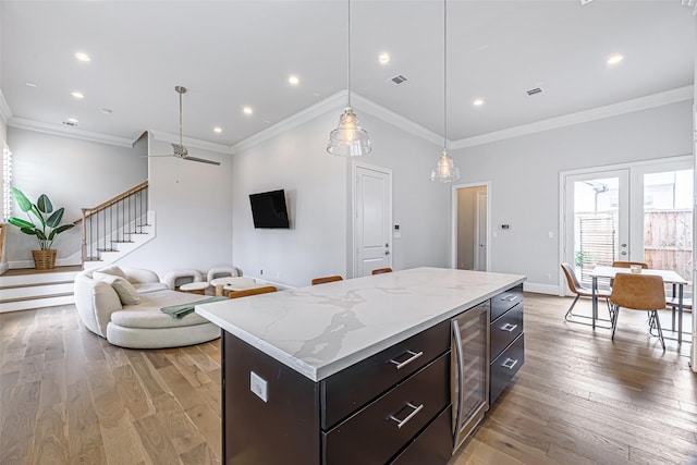2414 Hollister Rd, Houston, TX 77080 - kitchen featuring light wood-style floors, open floor plan, beverage cooler, a kitchen island, and baseboards