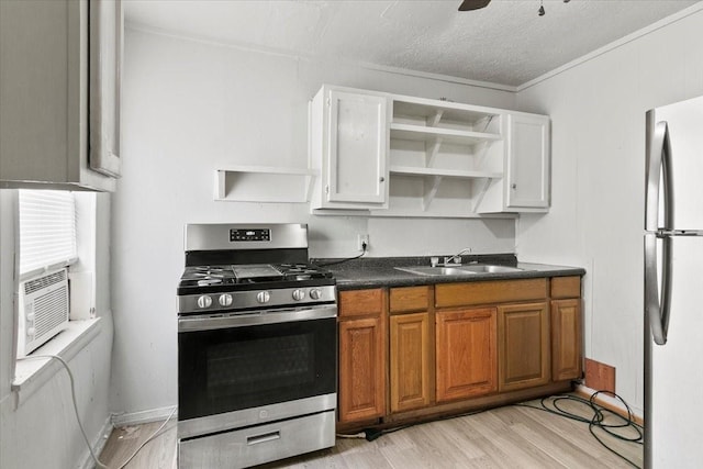 2905 Glenwood St, Beaumont, TX 77705 - kitchen featuring appliances with stainless steel finishes, a sink, open shelves, dark countertops, and light wood-style floors