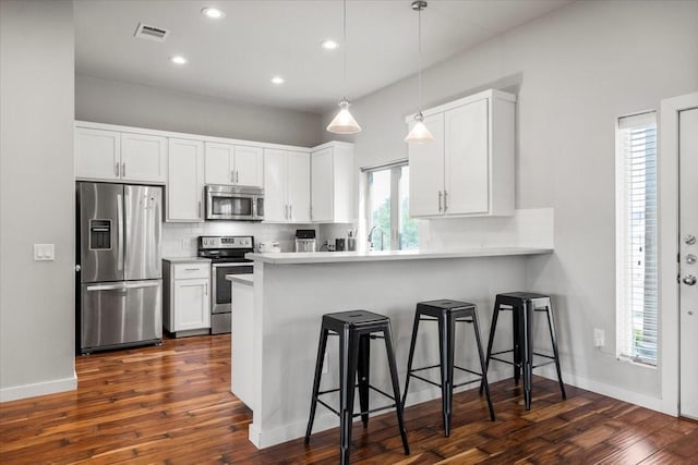 15202 Cavalier Canyon Dr, Lakeway, TX 78734 - kitchen featuring stainless steel appliances, a kitchen bar, tasteful backsplash, white cabinetry, and recessed lighting