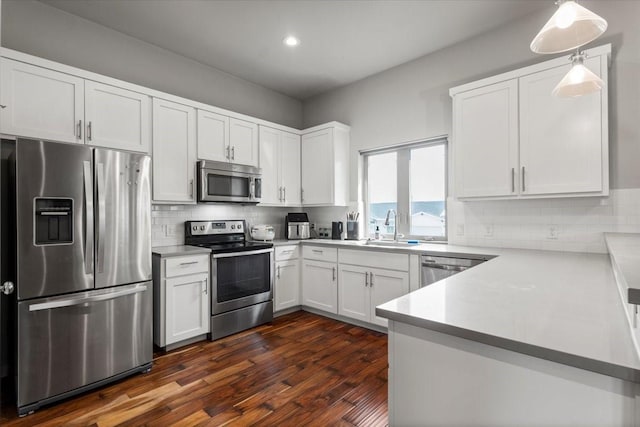 15202 Cavalier Canyon Dr, Lakeway, TX 78734 - kitchen with stainless steel appliances, a sink, white cabinets, dark wood-style flooring, and decorative backsplash